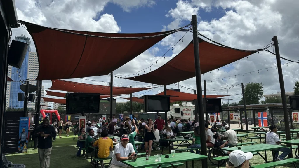 Shade sails over a busy outdoor bar patio