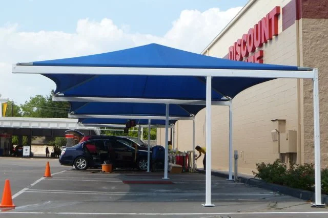 Row of blue T-cantilever shade structures in a parking lot