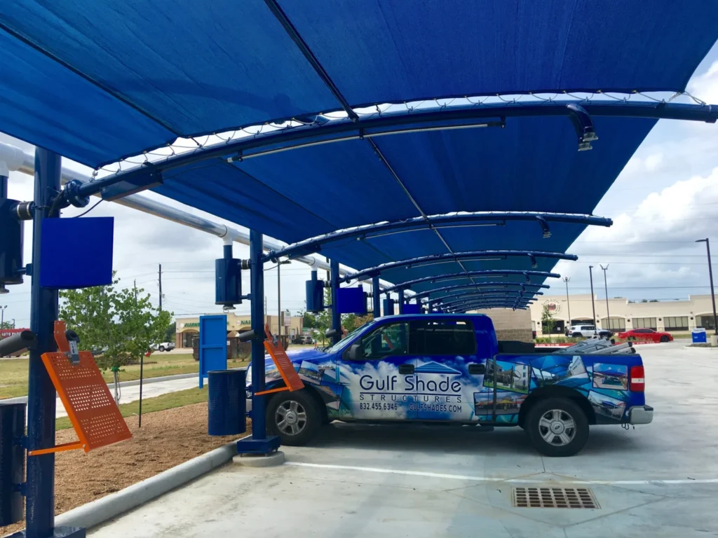Gulf Shades truck under new blue vacuum canopies at Blue Wave Car Wash