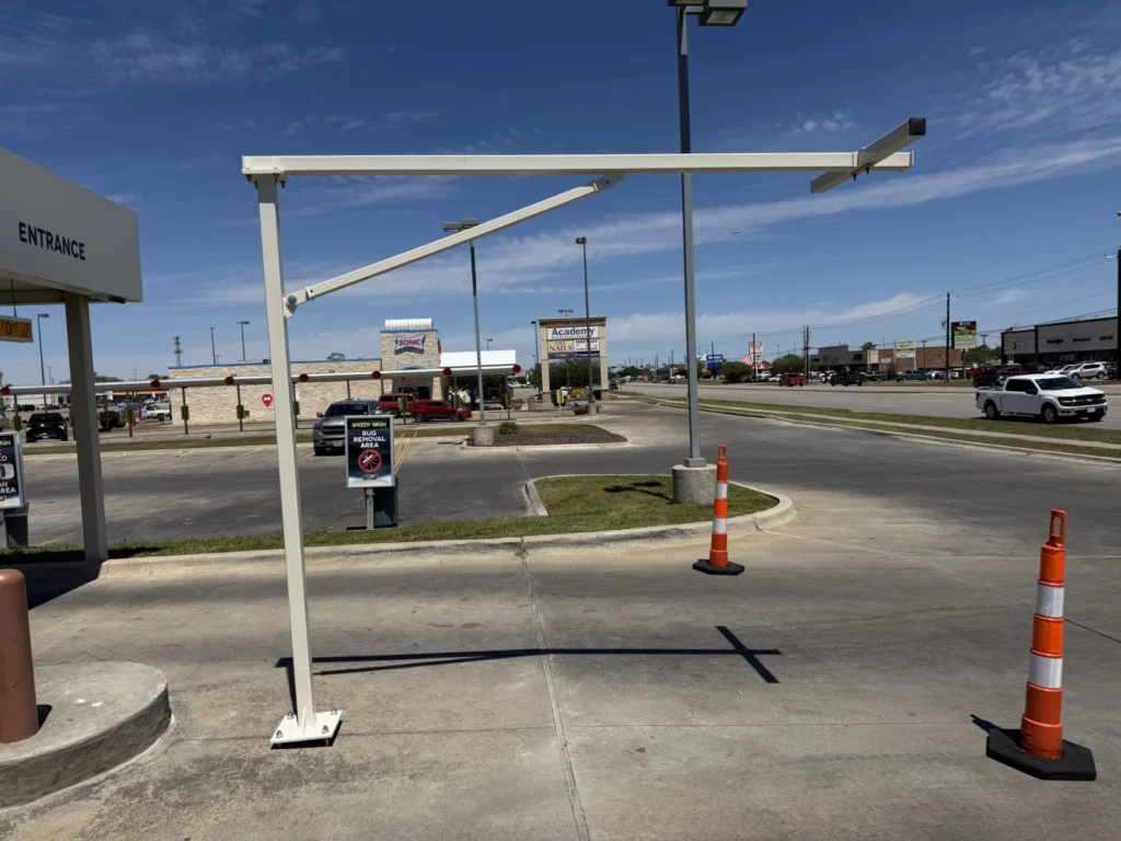 White steel camera pole at a car wash entrance