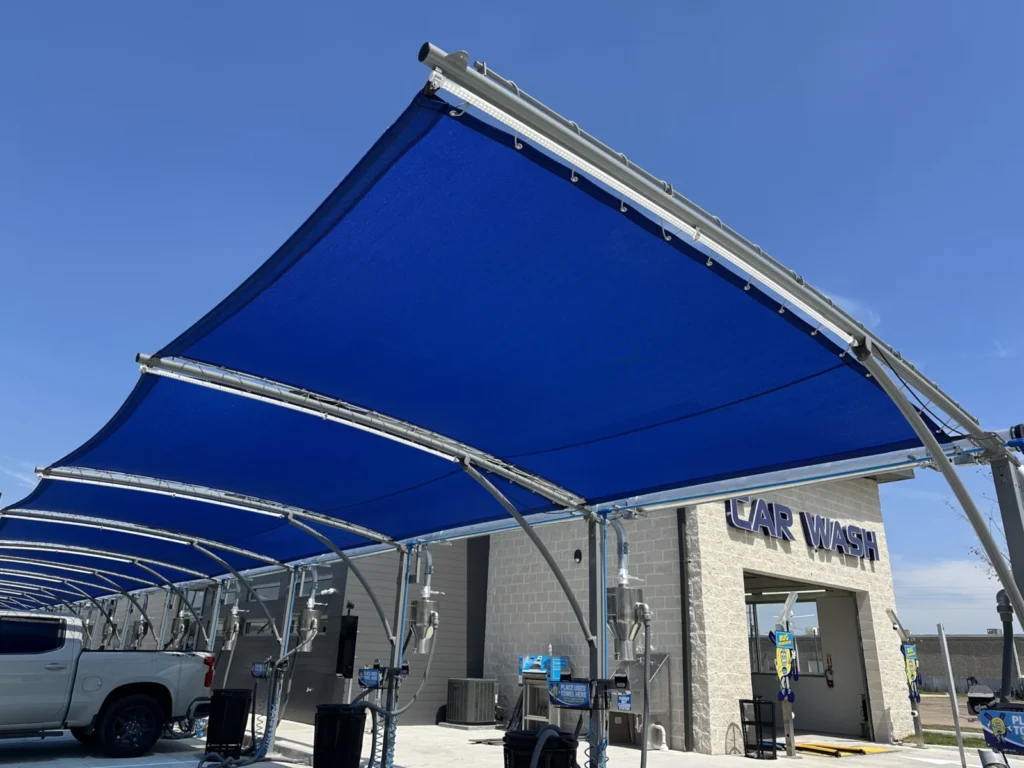 Blue shade sails over car wash vacuum lanes