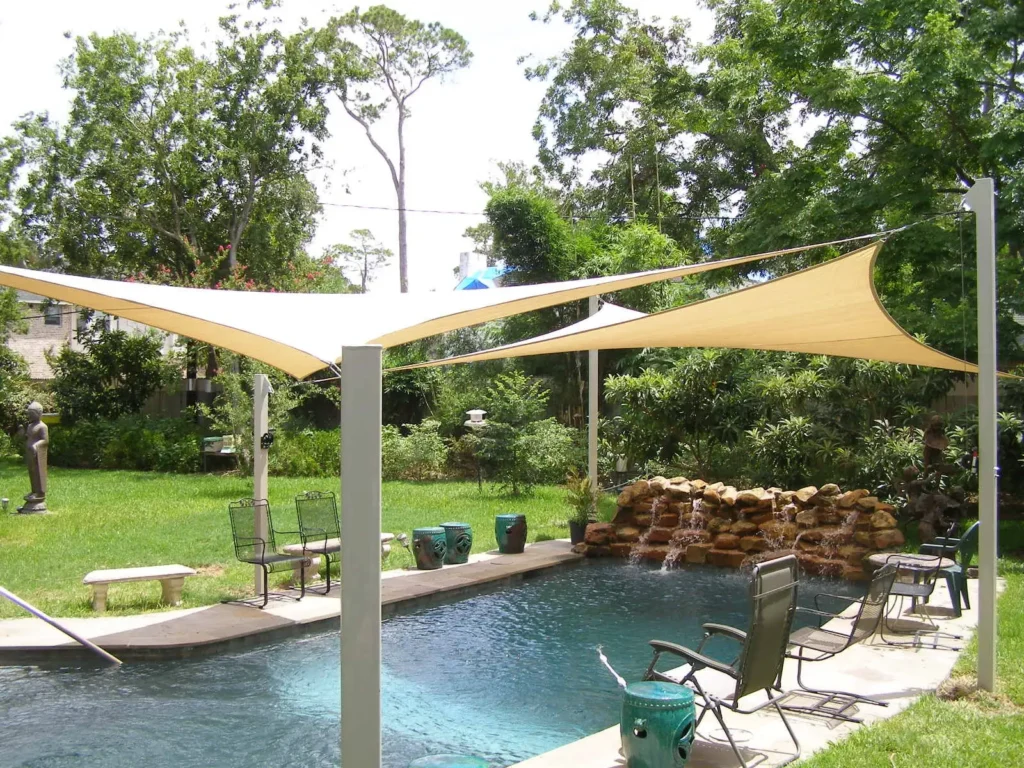 Triangular shade sails over a pool and waterfall