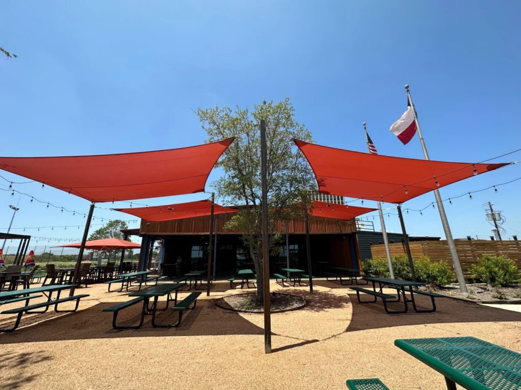 Red shade sails over a restaurant patio